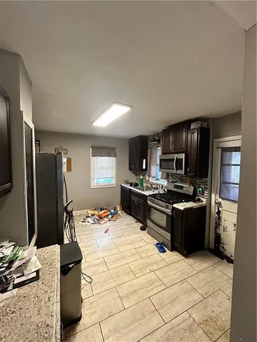 a kitchen with a refrigerator and a stove top oven