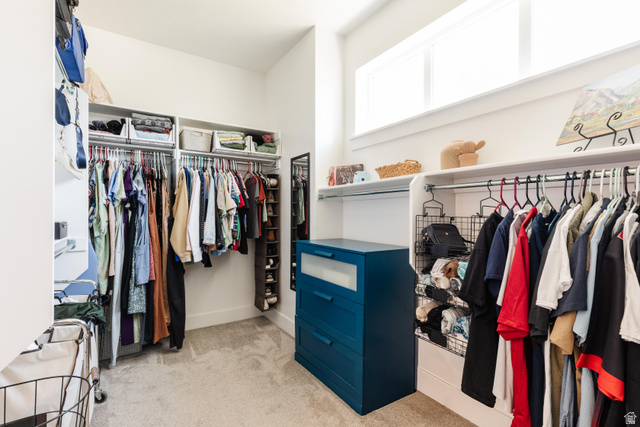 349 West 3085 South Logan, UT 84321 - Photo 17 of 37 Spacious closet featuring carpet flooring, built-in shelving, hanging rods, and a high-set transom window providing ambient light