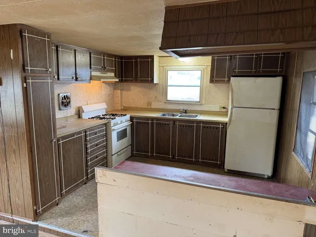 a kitchen with stainless steel appliances granite countertop a stove a refrigerator and a sink