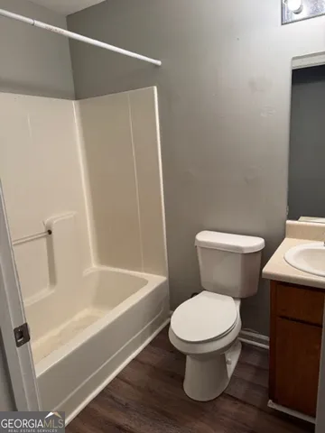 a white toilet sitting next to a bath tub