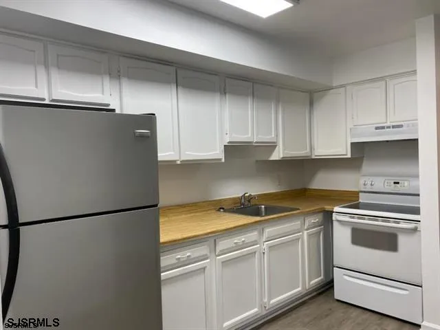 a kitchen with stainless steel appliances white cabinets and white appliances