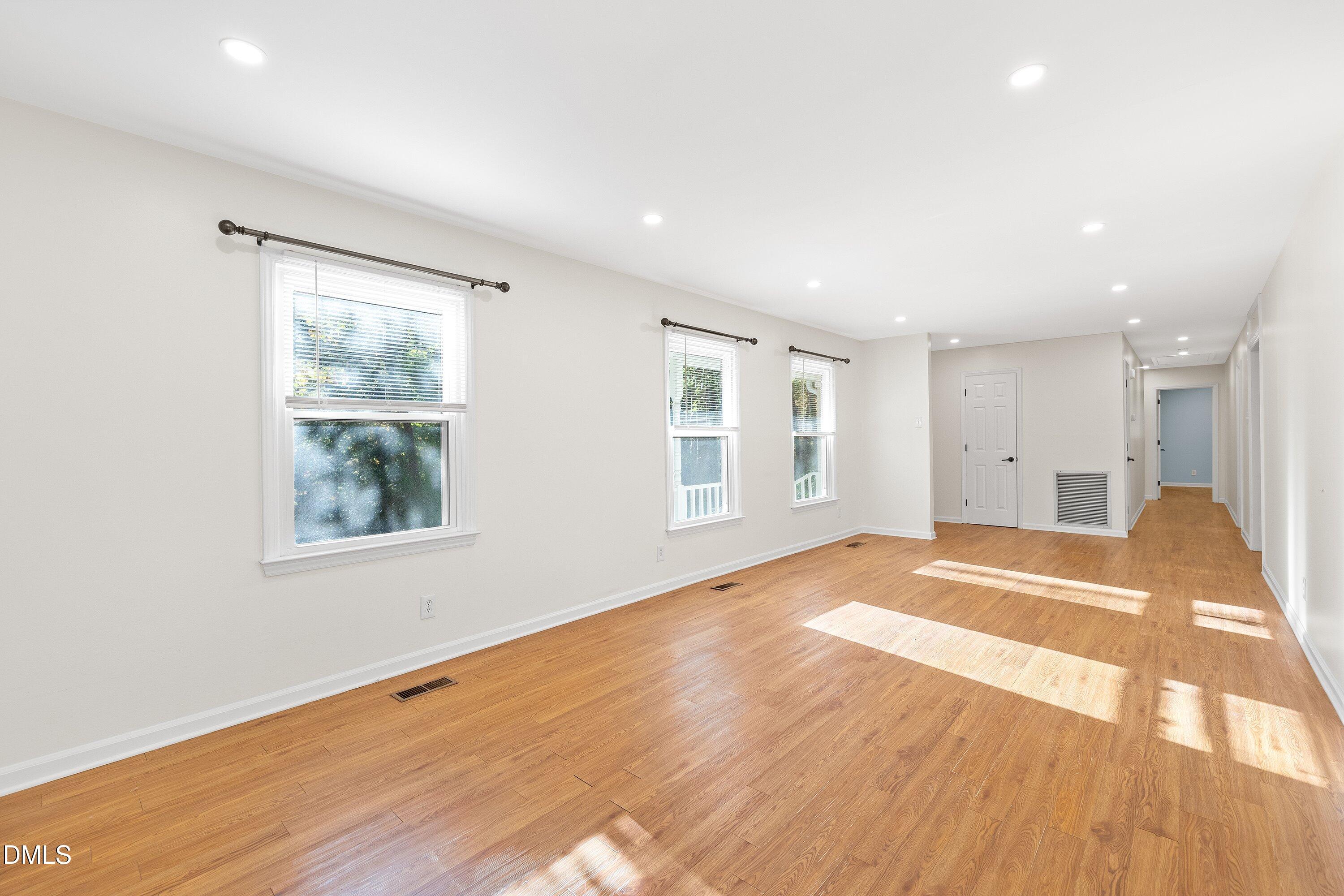 5917 Scalybark Road Durham, NC 27712 - Photo 11 of 47 a view of an empty room with wooden floor and a window