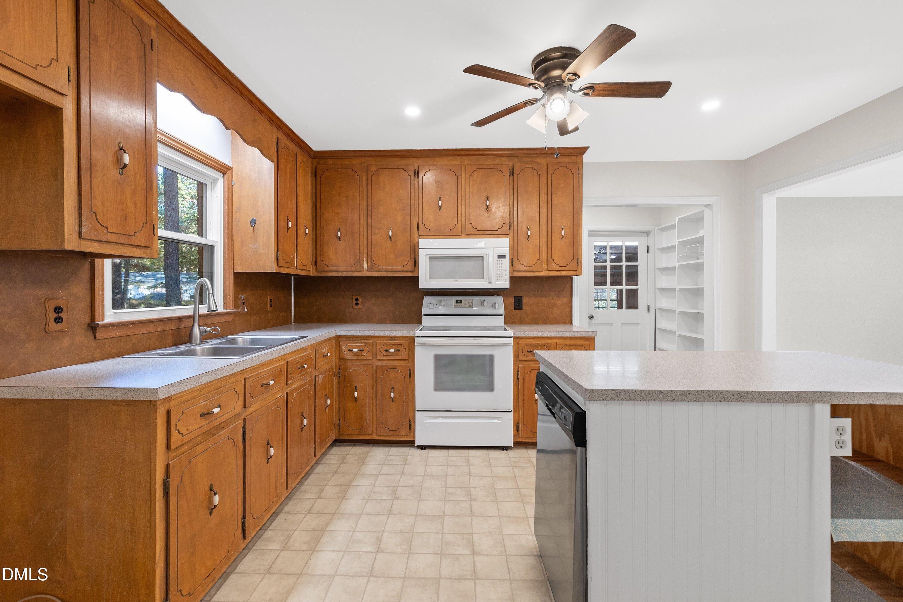 5917 Scalybark Road Durham, NC 27712 - Photo 15 of 47 a kitchen with a stove a sink and a refrigerator
