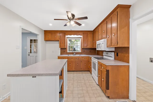 a large kitchen with a stove a refrigerator and a sink