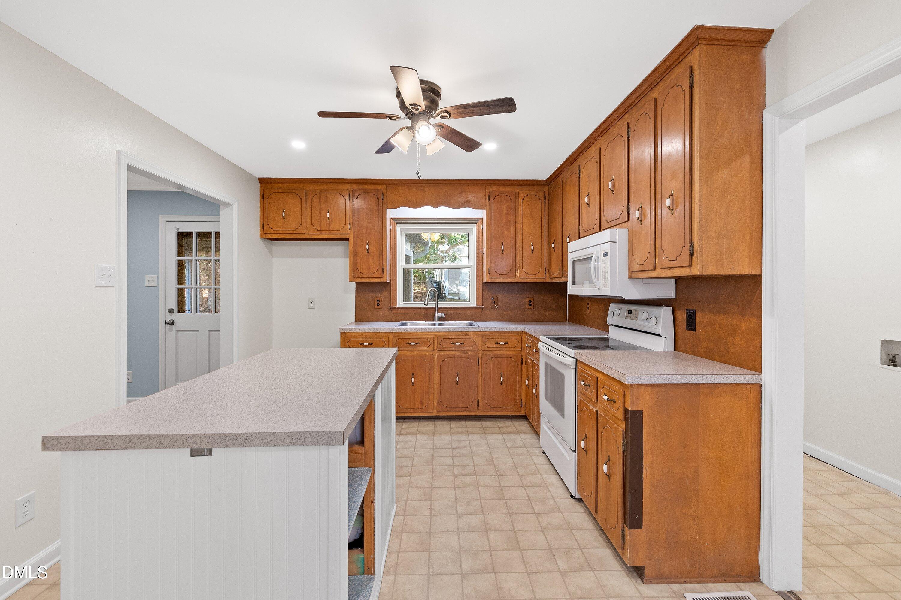 5917 Scalybark Road Durham, NC 27712 - Photo 18 of 47 a large kitchen with a stove a refrigerator and a sink