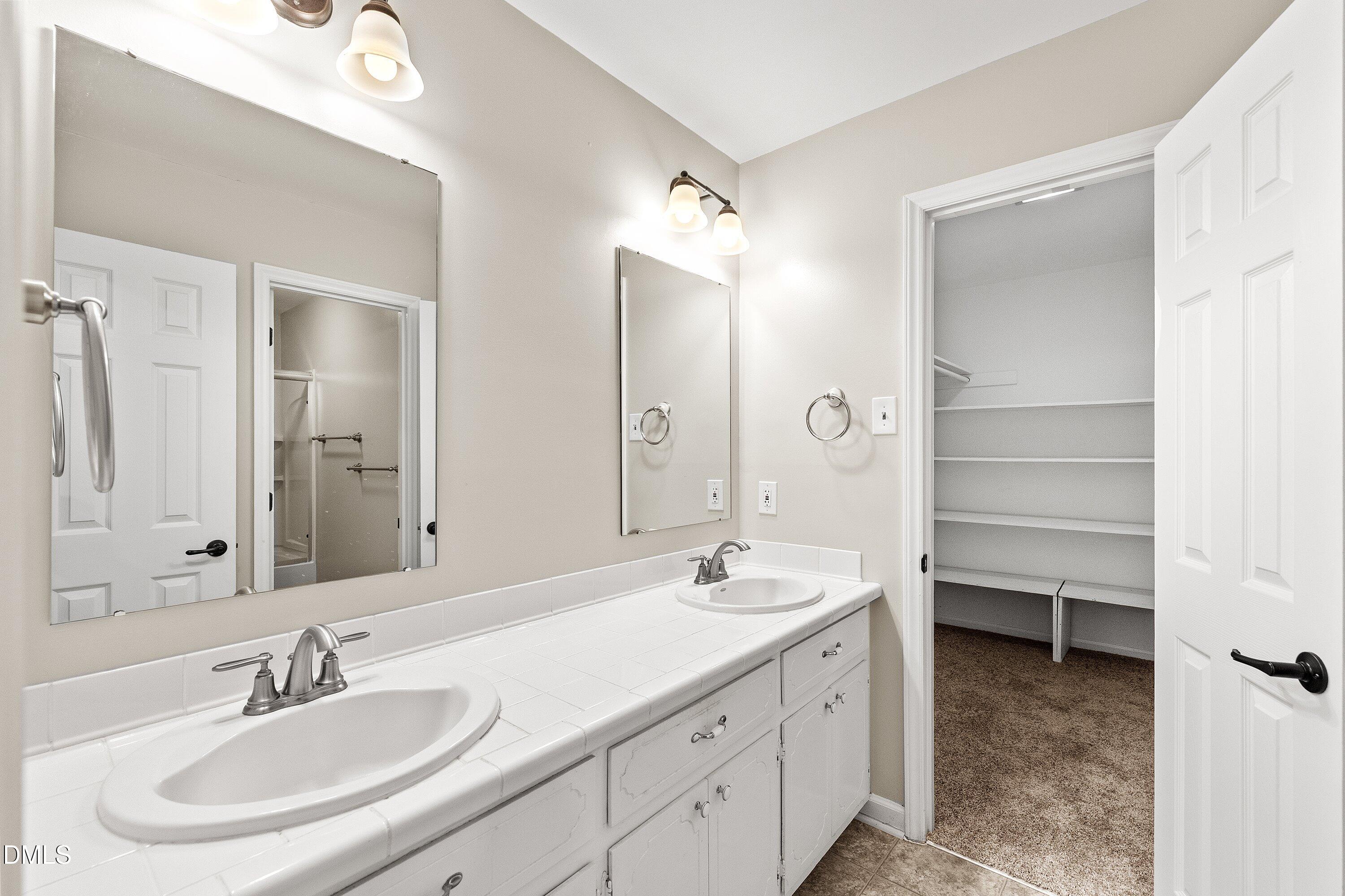 5917 Scalybark Road Durham, NC 27712 - Photo 24 of 47 a bathroom with a double vanity sink mirror and bathtub