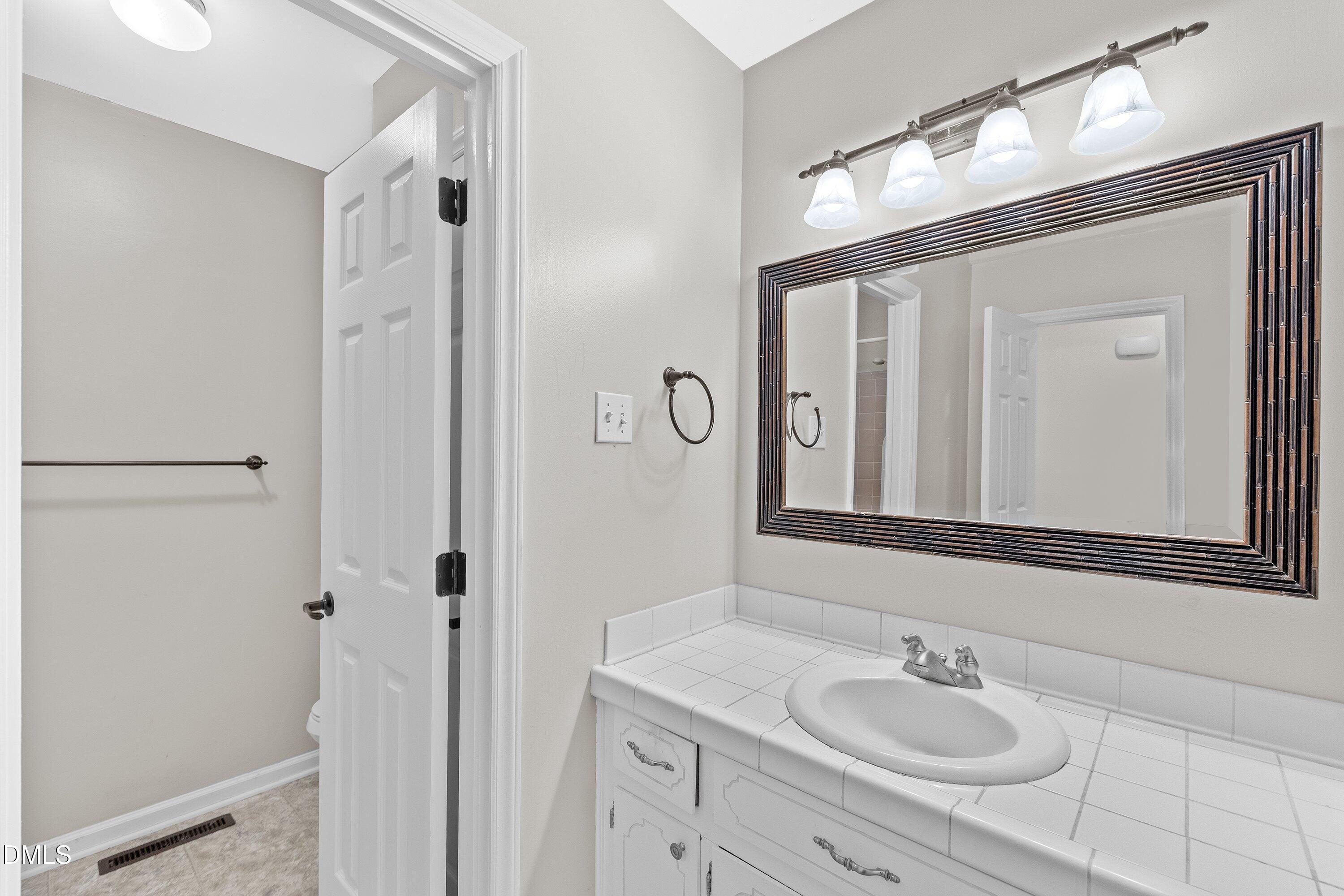 5917 Scalybark Road Durham, NC 27712 - Photo 31 of 47 a bathroom with a sink and a mirror