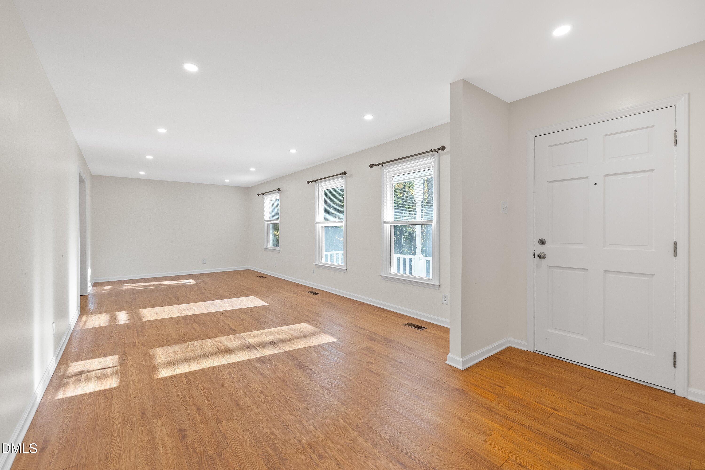 5917 Scalybark Road Durham, NC 27712 - Photo 8 of 47 a view of an empty room with wooden floor and a window