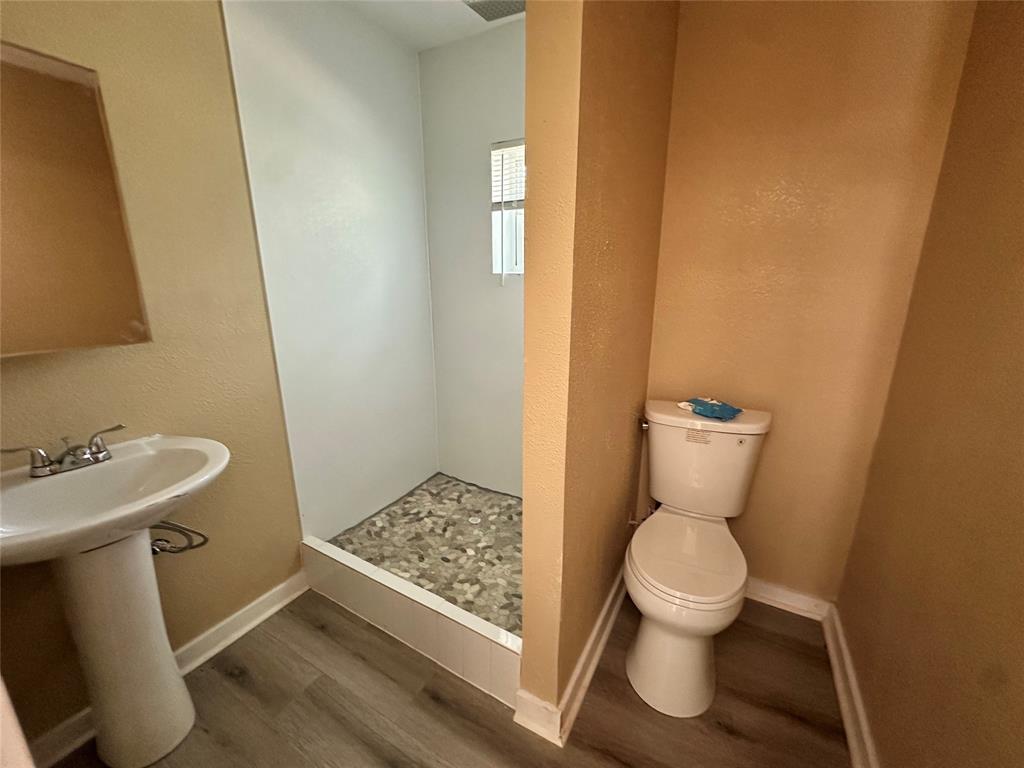 4101 North 19th Street Waco, TX 76708 - Photo 6 of 8 a white toilet sitting next to a bathroom sink