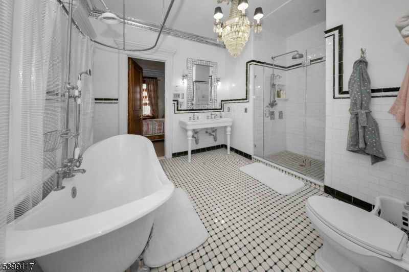 1 Hamilton Avenue Weehawken, NJ 07086 - Photo 28 of 40 a bathroom with a tub a sink and mirrors