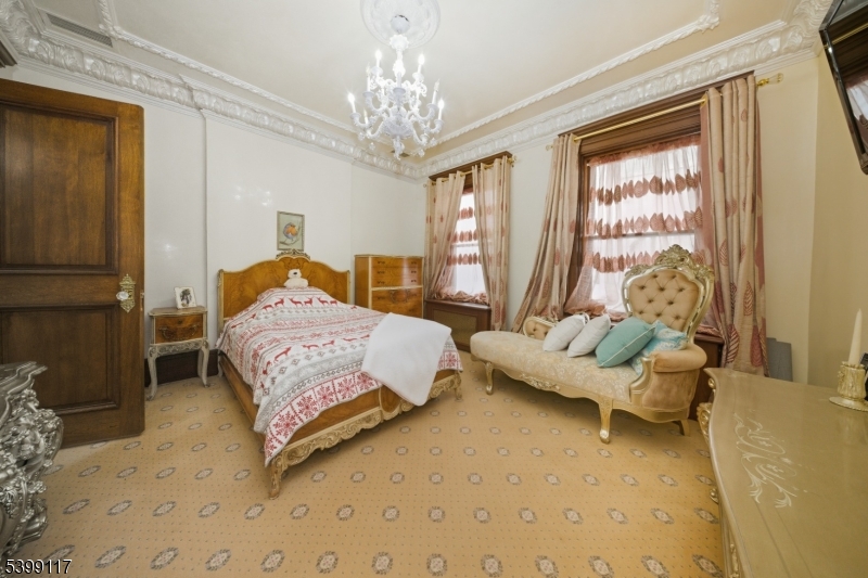 1 Hamilton Avenue Weehawken, NJ 07086 - Photo 30 of 40 a bedroom with a bed and a chandelier