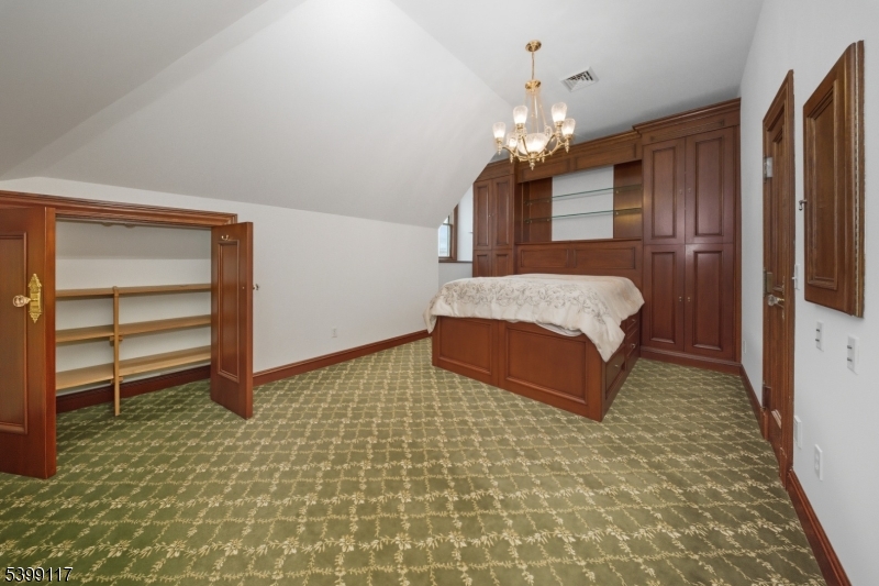 1 Hamilton Avenue Weehawken, NJ 07086 - Photo 34 of 40 a spacious bedroom with a bed and a chandelier