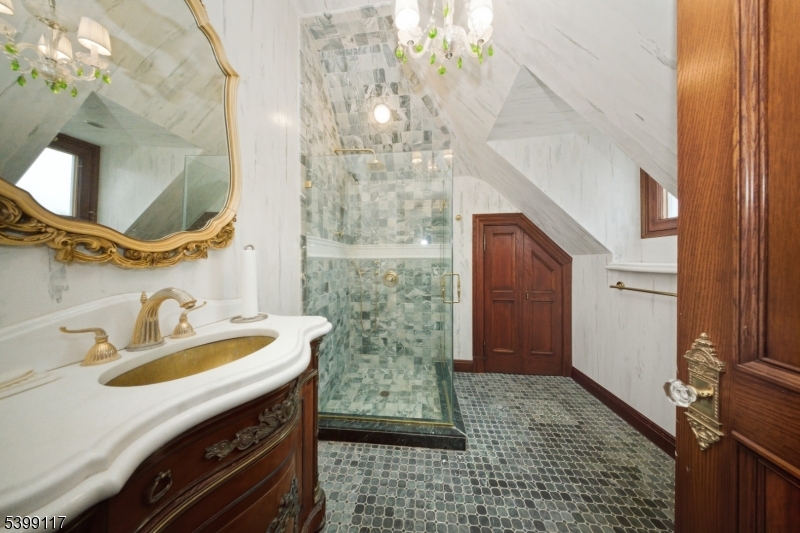 1 Hamilton Avenue Weehawken, NJ 07086 - Photo 35 of 40 a bathroom with a sink a mirror and shower