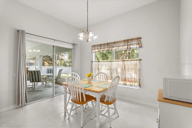 a dining room with furniture a chandelier and wooden floor