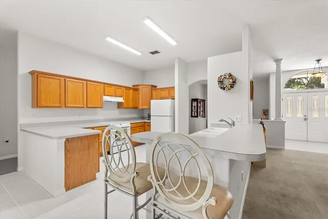 a large kitchen with kitchen island white cabinets and sink