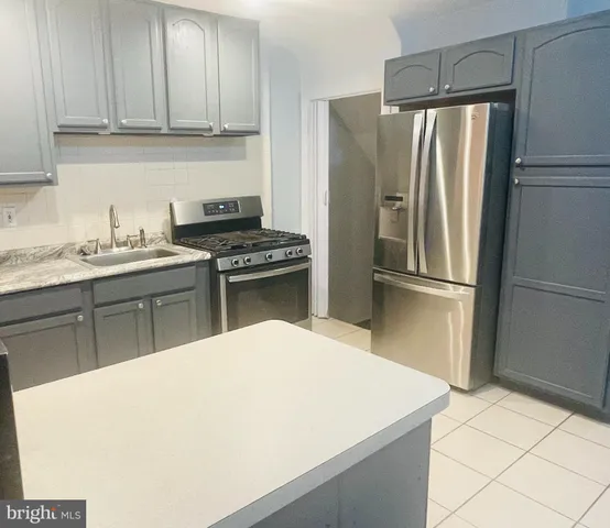 a kitchen with stainless steel appliances a refrigerator sink and cabinets