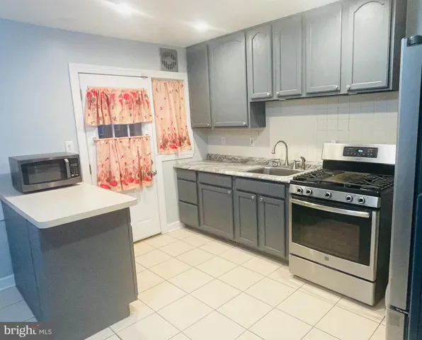 a kitchen with a stove sink and cabinets
