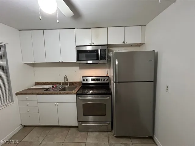 a kitchen with cabinets stainless steel appliances and a counter space