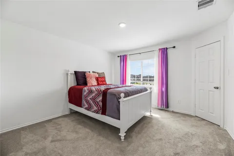 a spacious bedroom with a bed and a window