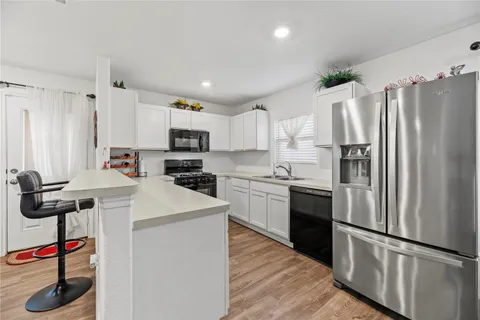 a kitchen with kitchen island a counter top space appliances and cabinets