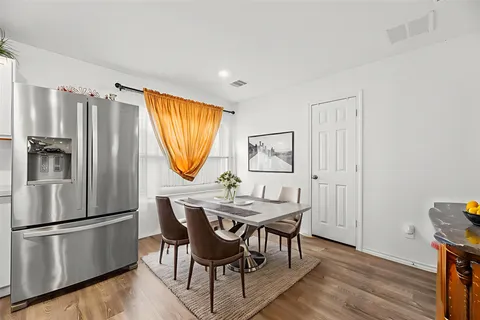 a dining room with furniture a window and wooden floor