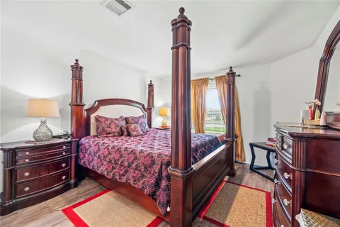 a bedroom with a bed and a dresser next to a window