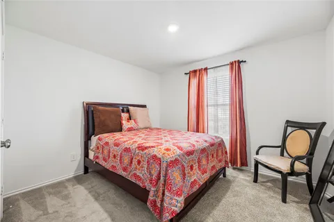 a bedroom with a bed chair and window