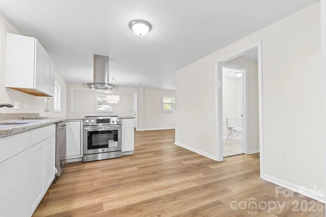 a view of open kitchen stove microwave and cabinets