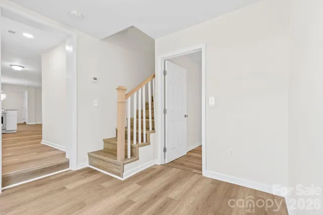 a view of a hallway with wooden floor and staircase