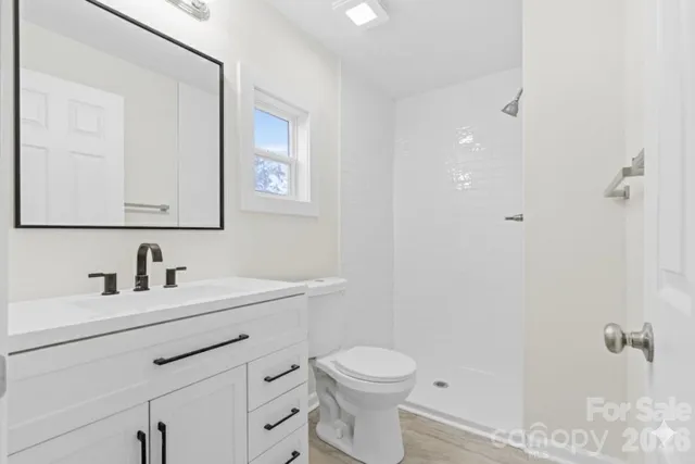 a bathroom with a toilet sink vanity and mirror