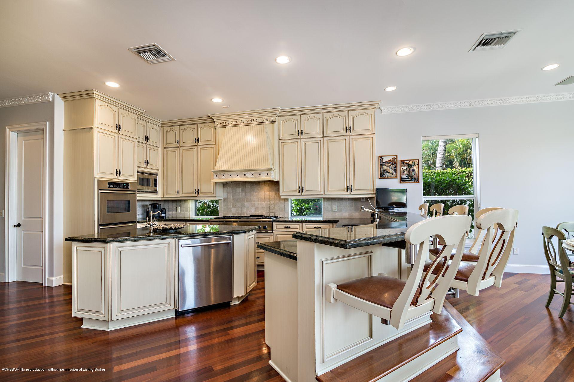 1121 Marble Way Boca Raton, FL 33432 - Photo 19 of 44 a kitchen with stainless steel appliances granite countertop a stove top oven a sink a refrigerator and white cabinets with wooden floor