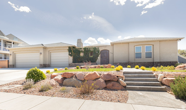 888 East Fiddlers Canyon Road Cedar City, UT 84721 - Photo 3 of 74 View of front of property featuring stone siding, a garage, stucco siding, concrete driveway, and a chimney