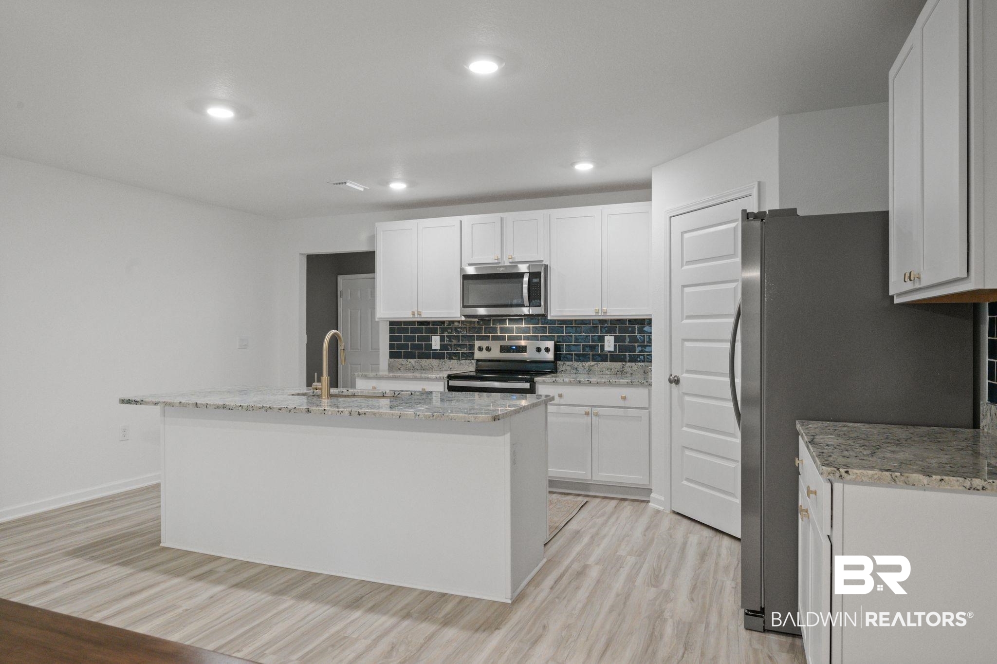 16272 Laurelbrooke Loop Fairhope, AL 36532 - Photo 32 of 40 Kitchen with white cabinetry, appliances with stainless steel finishes, sink, and a center island with sink