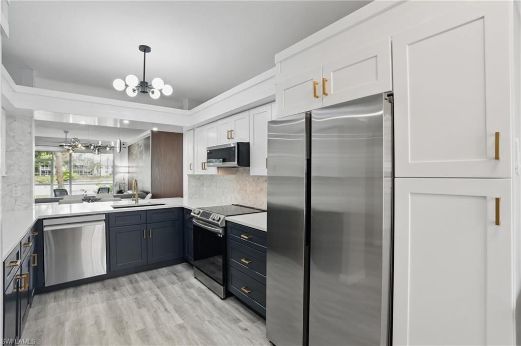 1220 Sarah Jean Circle, Unit L103 Naples, FL 34110 - Photo 13 of 50 a kitchen with stainless steel appliances granite countertop a refrigerator and a sink