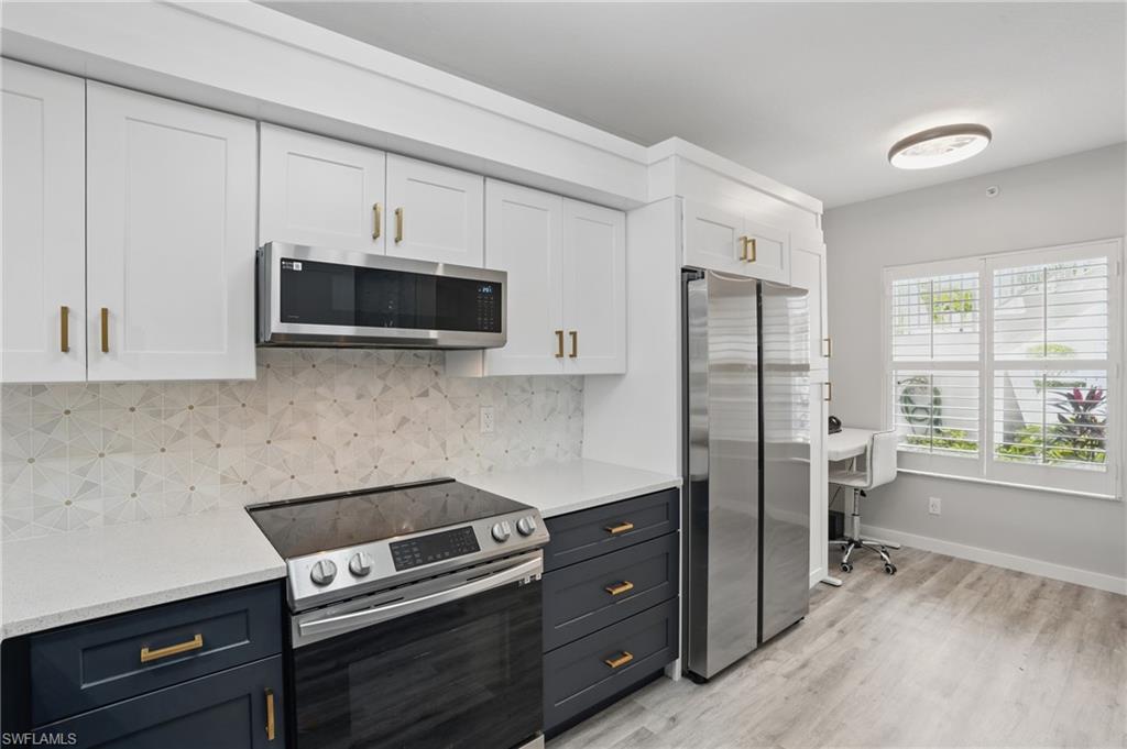 1220 Sarah Jean Circle, Unit L103 Naples, FL 34110 - Photo 14 of 50 a kitchen with stainless steel appliances a stove a refrigerator and a microwave