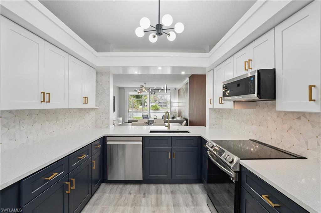 1220 Sarah Jean Circle, Unit L103 Naples, FL 34110 - Photo 15 of 50 Kitchen featuring a chandelier, appliances with stainless steel finishes, light countertops, and a sink