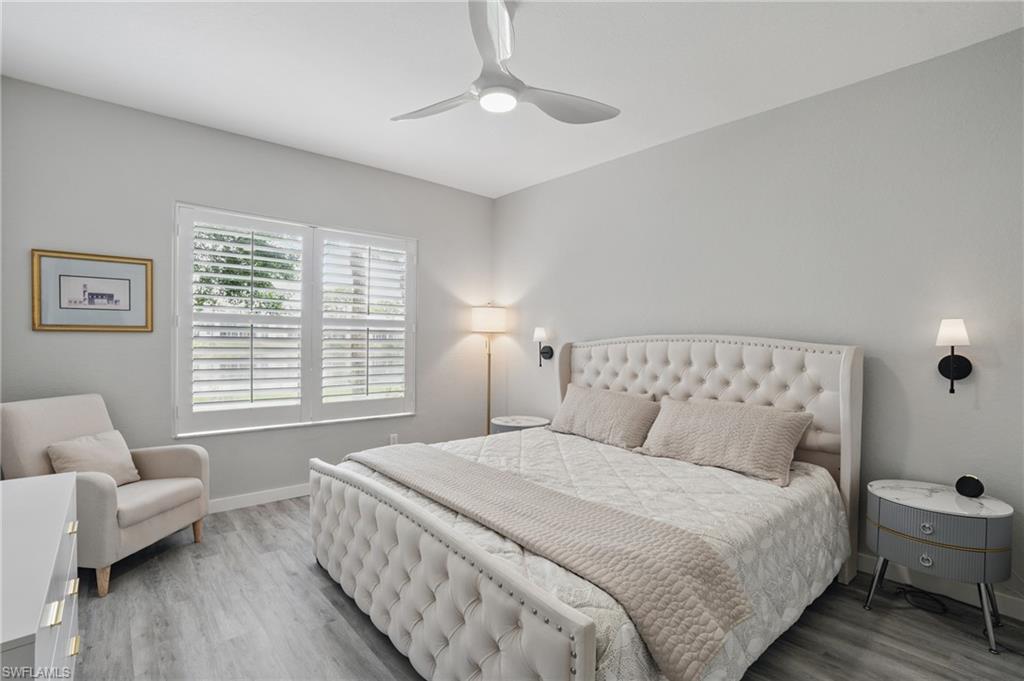 1220 Sarah Jean Circle, Unit L103 Naples, FL 34110 - Photo 18 of 50 Bedroom with baseboards, wood finished floors, and ceiling fan