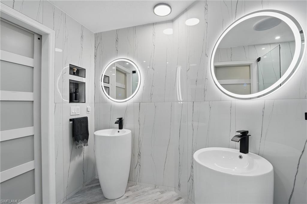 1220 Sarah Jean Circle, Unit L103 Naples, FL 34110 - Photo 21 of 50 a bathroom with a sink and a mirror