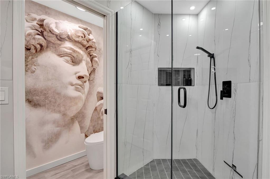 1220 Sarah Jean Circle, Unit L103 Naples, FL 34110 - Photo 22 of 50 Full bath featuring a marble finish shower and wood finished floors