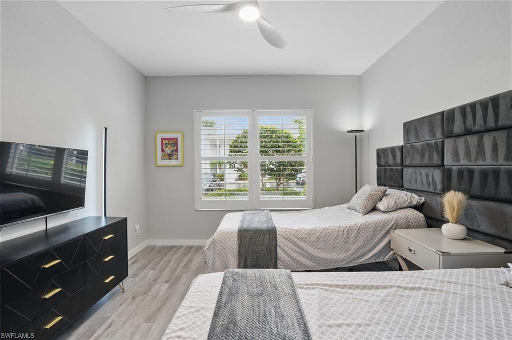 1220 Sarah Jean Circle, Unit L103 Naples, FL 34110 - Photo 24 of 50 a bedroom with a bed and a flat screen tv