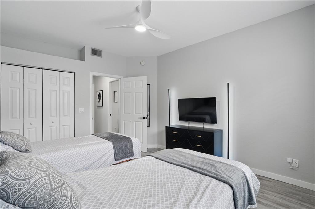 1220 Sarah Jean Circle, Unit L103 Naples, FL 34110 - Photo 25 of 50 a bedroom with a bed and a flat tv screen on dresser