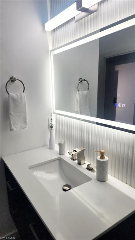 1220 Sarah Jean Circle, Unit L103 Naples, FL 34110 - Photo 27 of 50 a bathroom with a sink and a mirror