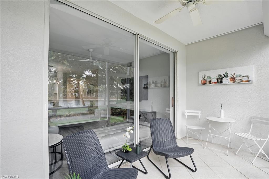 1220 Sarah Jean Circle, Unit L103 Naples, FL 34110 - Photo 29 of 50 Sunroom featuring a ceiling fan, a textured wall, and tile patterned floors