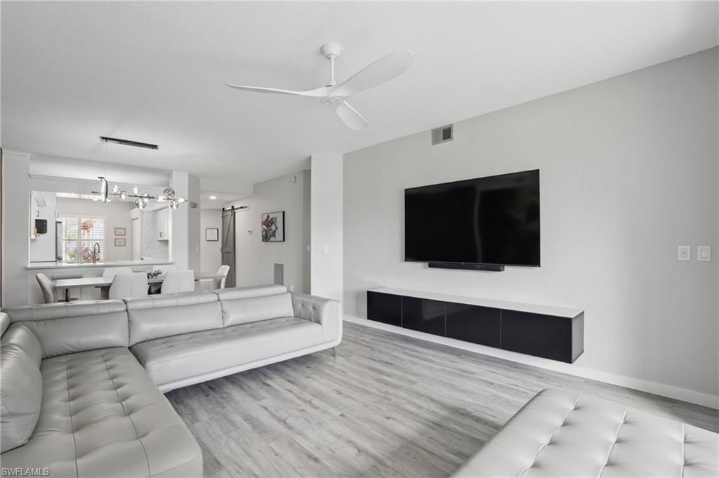 1220 Sarah Jean Circle, Unit L103 Naples, FL 34110 - Photo 3 of 50 a living room with furniture and a flat screen tv