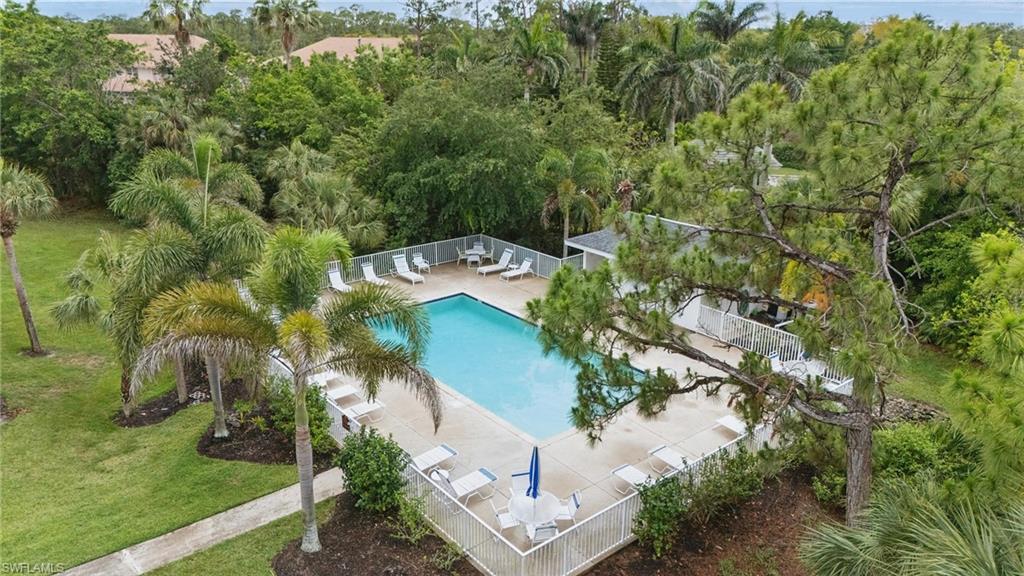 1220 Sarah Jean Circle, Unit L103 Naples, FL 34110 - Photo 42 of 50 Aerial view of a pool and a tree filled landscape
