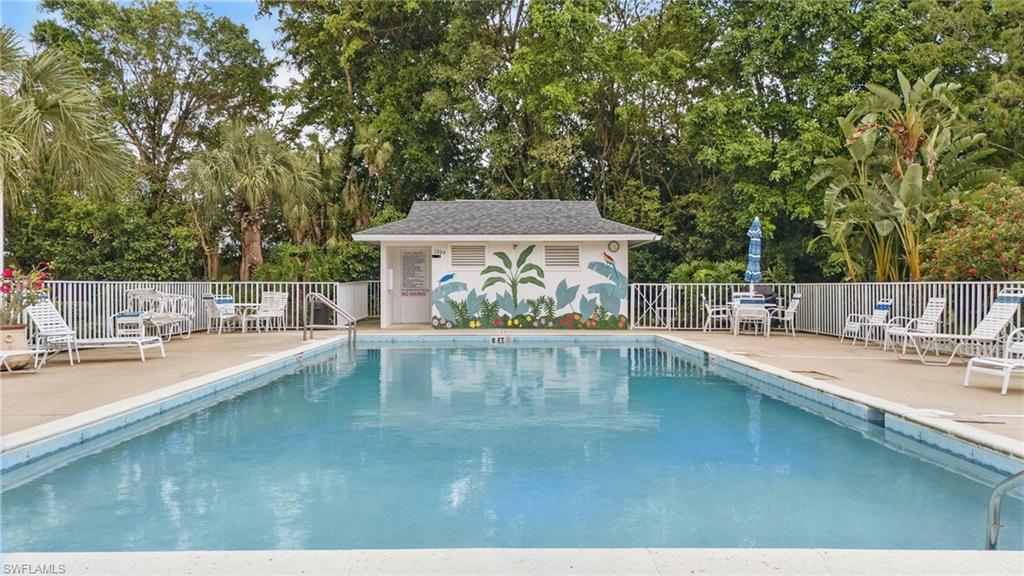 1220 Sarah Jean Circle, Unit L103 Naples, FL 34110 - Photo 44 of 50 Community pool with fence, a patio, and view of scattered trees