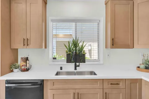 a kitchen with stainless steel appliances white cabinets and a window