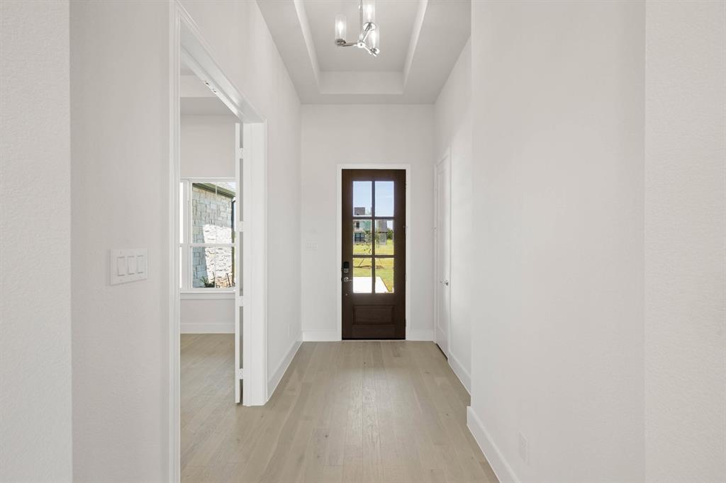 141 Olson Road Waxahachie, TX 75165 - Photo 3 of 24 a view of a hallway with wooden floor and a window