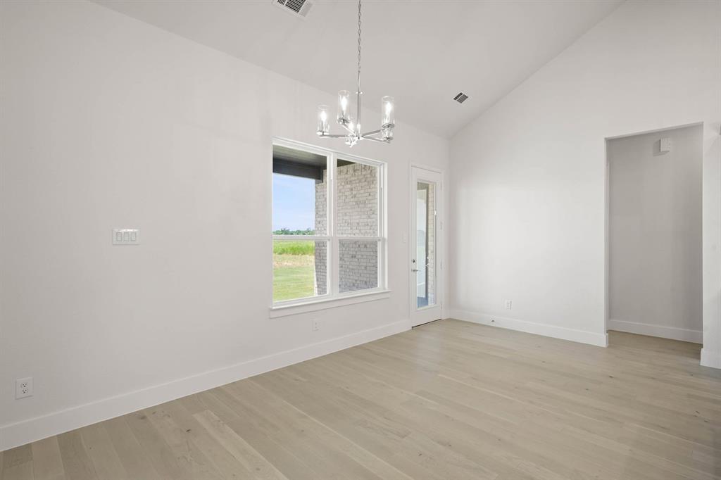 141 Olson Road Waxahachie, TX 75165 - Photo 6 of 24 an empty room with windows and chandelier