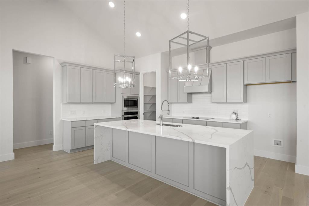141 Olson Road Waxahachie, TX 75165 - Photo 7 of 24 a kitchen with kitchen island white cabinets and white appliances